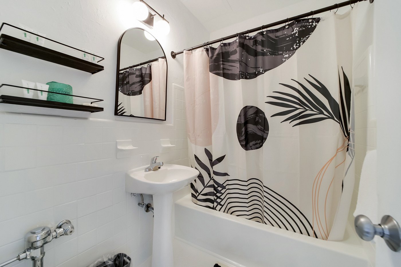 A clean bathroom with a bathtub, sink, and mirror