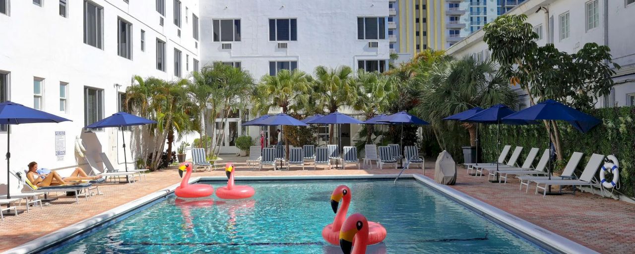 a pool with flamingo floats and lounge chairs