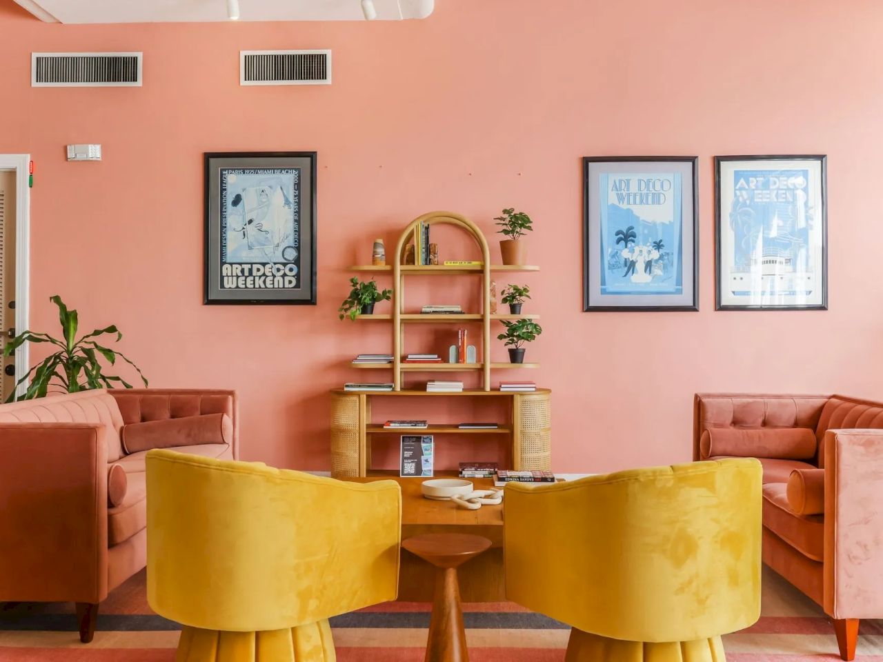 A seating area with yellow chairs and pink walls